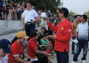 Bupati Sukamara dan Ketua TP-PKK Bagikan Susu dan Masker untuk Warga Ajang